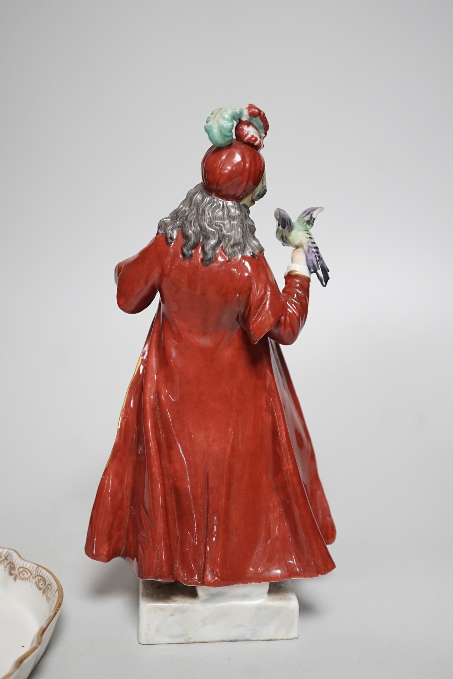 A 19th century German Inkstand with two pots and covers painted with flowers, 24cm wide, and a Volkstedt figure of an eastern European woman holding a bird	